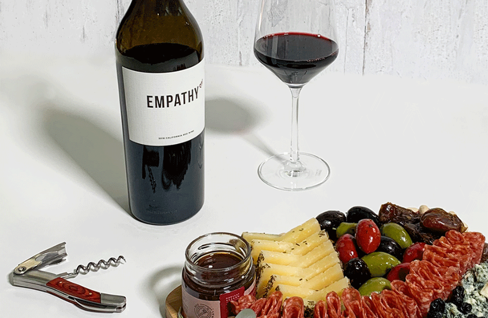Empathy Red Blend next to a charcuterie board